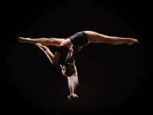 Une acrobate qui se tient en équilibre sur un bras.