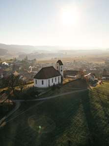 Village de Wilchingen Sur une colline couverte de vignes se trouve une église. Derrière, on voit le village.