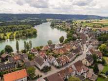 On y voit un village vu d'en haut, situé directement au bord du Rhin.