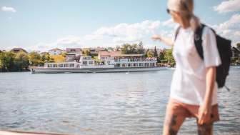 Navigation à hoiraire régulier sur le Rhin Une femme montre du doigt la navigation à horaire régulier qui passe sur le Rhin.