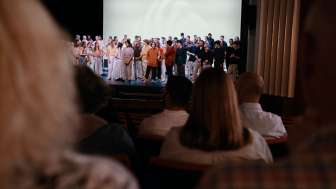 Municipal theatre de Schaffhouse Spectacle avec public Une scène de théâtre avec de très nombreux artistes. Dans la salle, des spectateurs sont assis sur les sièges rouges.