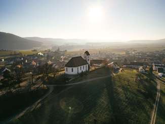 Village de Wilchingen Sur une colline couverte de vignes se trouve une église. Derrière, on voit le village.
