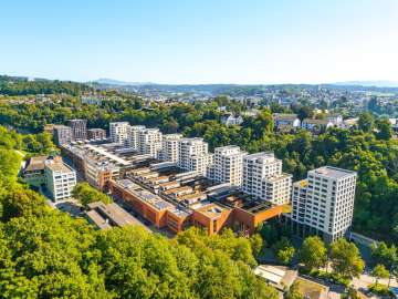Vue aérienne de la fonderie d'acier. Des immeubles d'habitation modernes côtoient une ancienne zone industrielle.