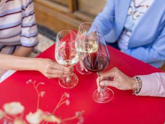 Jeudi de la Wii Trois personnes trinquent avec deux verres de vin blanc et un verre de vin rouge. Ils sont assis à une petite table rouge.