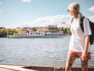 Une femme montre du doigt la navigation à horaire régulier qui passe sur le Rhin.