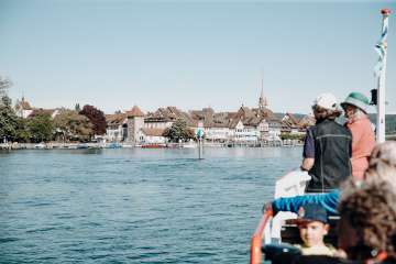 Plusieurs personnes sont à bord du bateau. En regardant devant soi, on aperçoit le débarcadère Stein am Rhein.