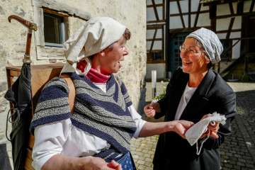 Deux femmes déguisées en épiciers bavardent ensemble.