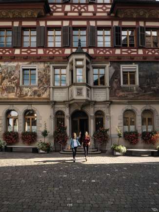 Mairie de Stein am Rhein Deux amies se tiennent devant l'hôtel de ville de Stein am Rhein et observent les peintures de la façade.