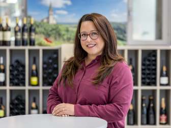 Portrait de Tanja Hürlimann. Elle porte un chemisier de couleur bordeaux. Elle a de longs cheveux bruns et porte une birlle.