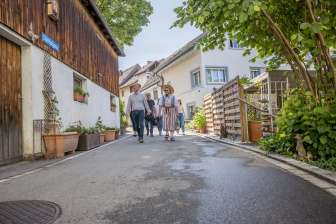Visite guidée de Hallau Groupe avec un guide en costume traditionnel marchant dans une petite ruelle.