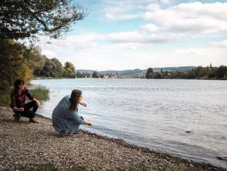 Deux amies posent des pierres sur la rive du Rhin, devant Stein am Rhein.
