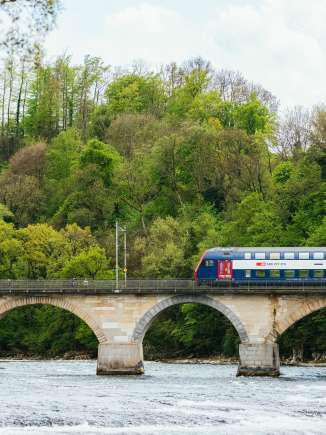 Un train des CFF traverse le pont des chutes du Rhin depuis le bord droit de l'image.