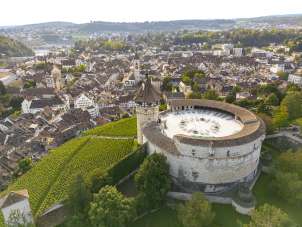 Munot Schaffhouse Vue d'en haut sur la forteresse ronde et le coteau viticole. Derrière la forteresse, on aperçoit la vieille ville de Schaffhouse.