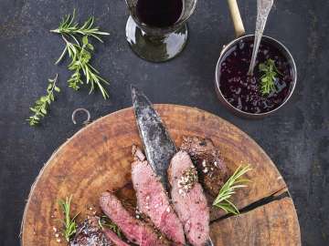 Plusieurs morceaux de gibier sont disposés sur un plateau en bois.