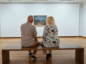Musée de Allerheiligen Un homme et une femme sont assis sur un banc dans une exposition d'art. Ils regardent tous les deux un tableau.