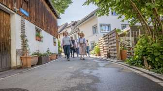 Visite guidée de Hallau Groupe avec un guide en costume traditionnel marchant dans une petite ruelle.