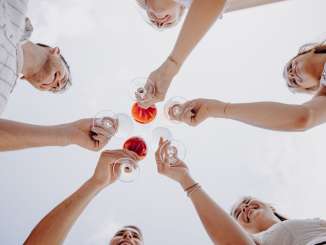 Fête du Räbhüüsli à Hallau Cinq amis tiennent des verres de vin en l'air et trinquent.