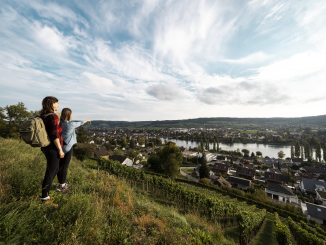 Deux randonneurs se tiennent dans un champ surplombant les vignes et la ville Stein am Rhein profitent de la vue sur la vieille ville et le Rhin.