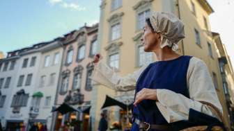 La personne Commerçante en Commerçante désigne du doigt un site touristique.