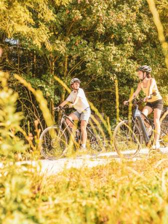 Veofahren Beringen Deux amies font du vélo électrique à la lisière de la forêt sur un chemin de terre.