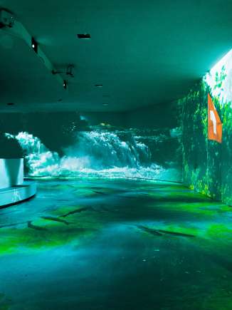 Une salle équipée de divers projecteurs. Des images d'eau sont projetées sur les murs.
