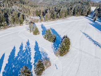 Piste de ski de fond Randen Vue d'en haut sur la piste de ski de fond à travers une surface ouverte. Une personne s'y promène. Il y a encore un peu de neige sur les sapins.