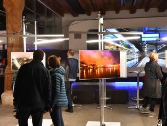 Une exposition de photos avec divers visiteurs qui étudient les images.