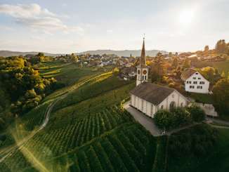 Vue dans la lumière dorée du soir sur l'église Buchberg  Rüdlingen les vignes. Derrière, on aperçoit un village.