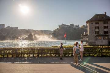 Visite guidée des chutes du Rhin Un groupe avec un guide se tiennent devant les chutes du Rhin, la plus grande chute d'eau d'Europe.