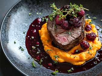 Du gibier dans une assiette Un morceau de viande est disposé sur une assiette.