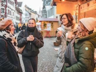 steinamrhein-maerlistadt-décembre-hiver (9) Quatre femmes à un marché de Noël, un gobelet de vin chaud à la main.