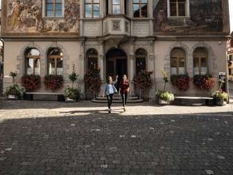 Mairie de Stein am Rhein Deux amies se tiennent devant l'hôtel de ville de Stein am Rhein et observent les peintures de la façade.