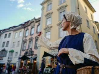 La personne Commerçante en Commerçante désigne du doigt un site touristique.